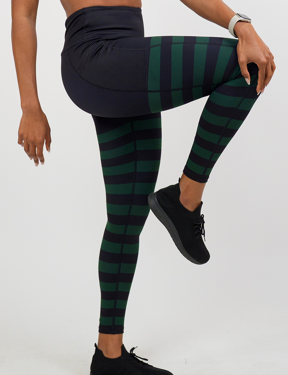 full length green stripe against a dark background leggings facing the side against a white background