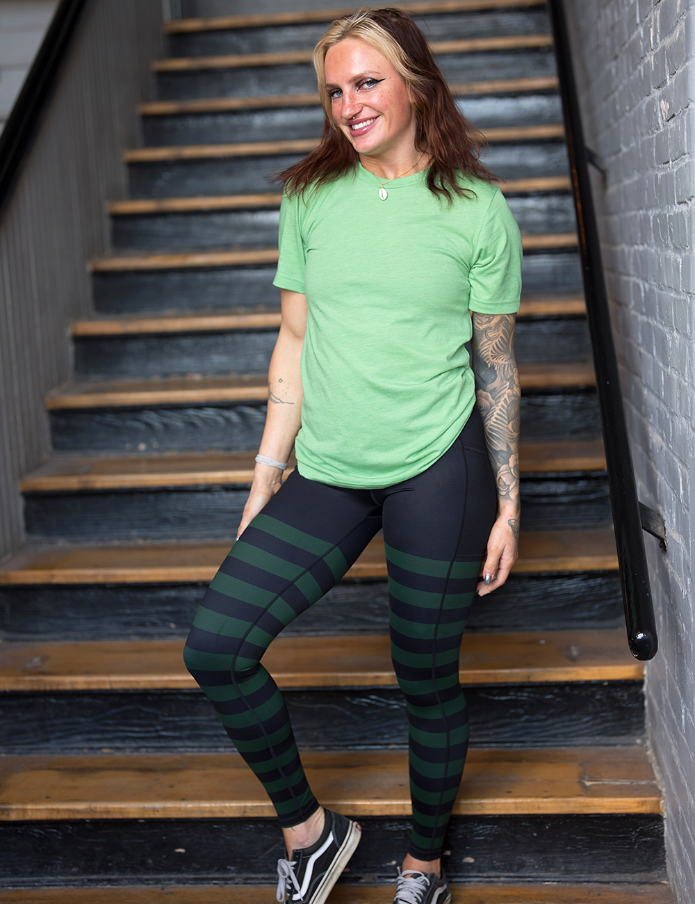 full length green stripe against a dark background leggings facing the side against a white background