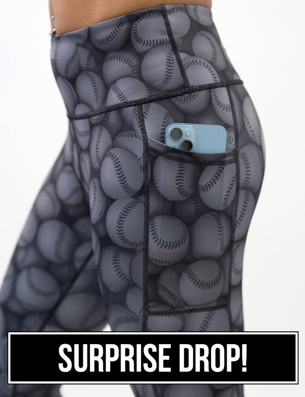 close up of the dark grey baseball patterned leggings with a phone in its pocket against a white background, surprise drop