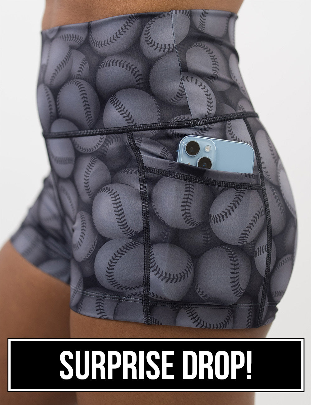 close up of the dark grey baseball patterned 2.5 inch shorts with a phone in its pocket, surprise drop