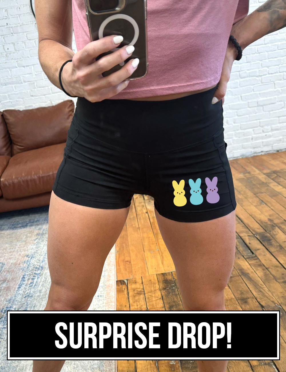 model wearing 2.5" black shorts with three peeps on the left corner. One is yellow, one is blue, and the other is purple surprise drop.