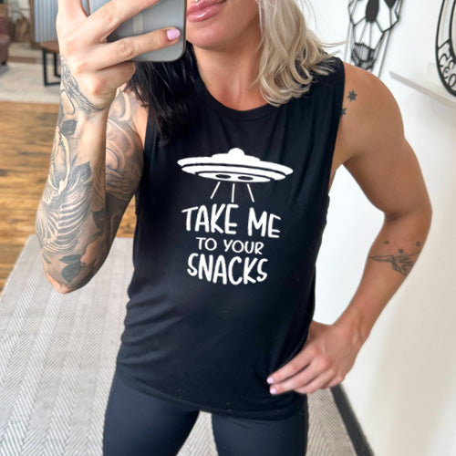 black muscle tank top with a white quote on it that says "take me to your snacks" with a ufo on top of it