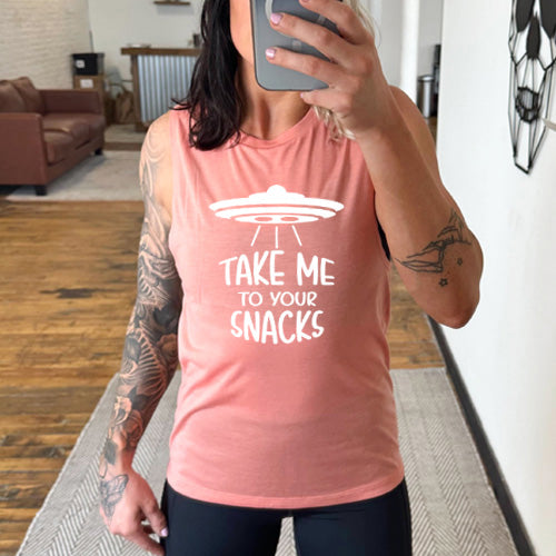 peach muscle tank top with a white quote on it that says "take me to your snacks" with a ufo on top of it