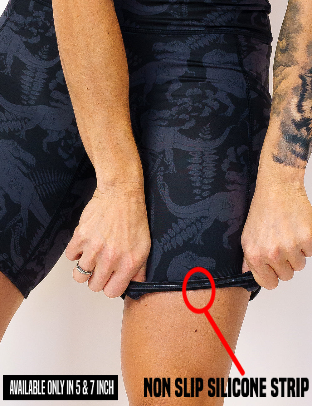 close up of the black on black dinosaur printed shorts rolled up to show the non slip silicone strip found in the 5 and 7 inch shorts