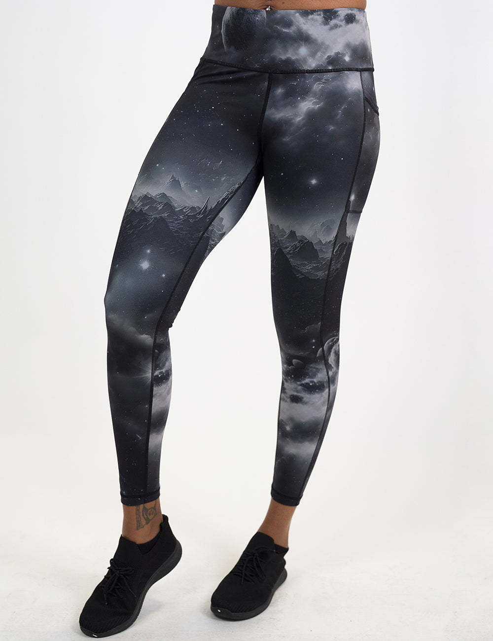 model wearing the full length black leggings with mountain and star pattern against a white background