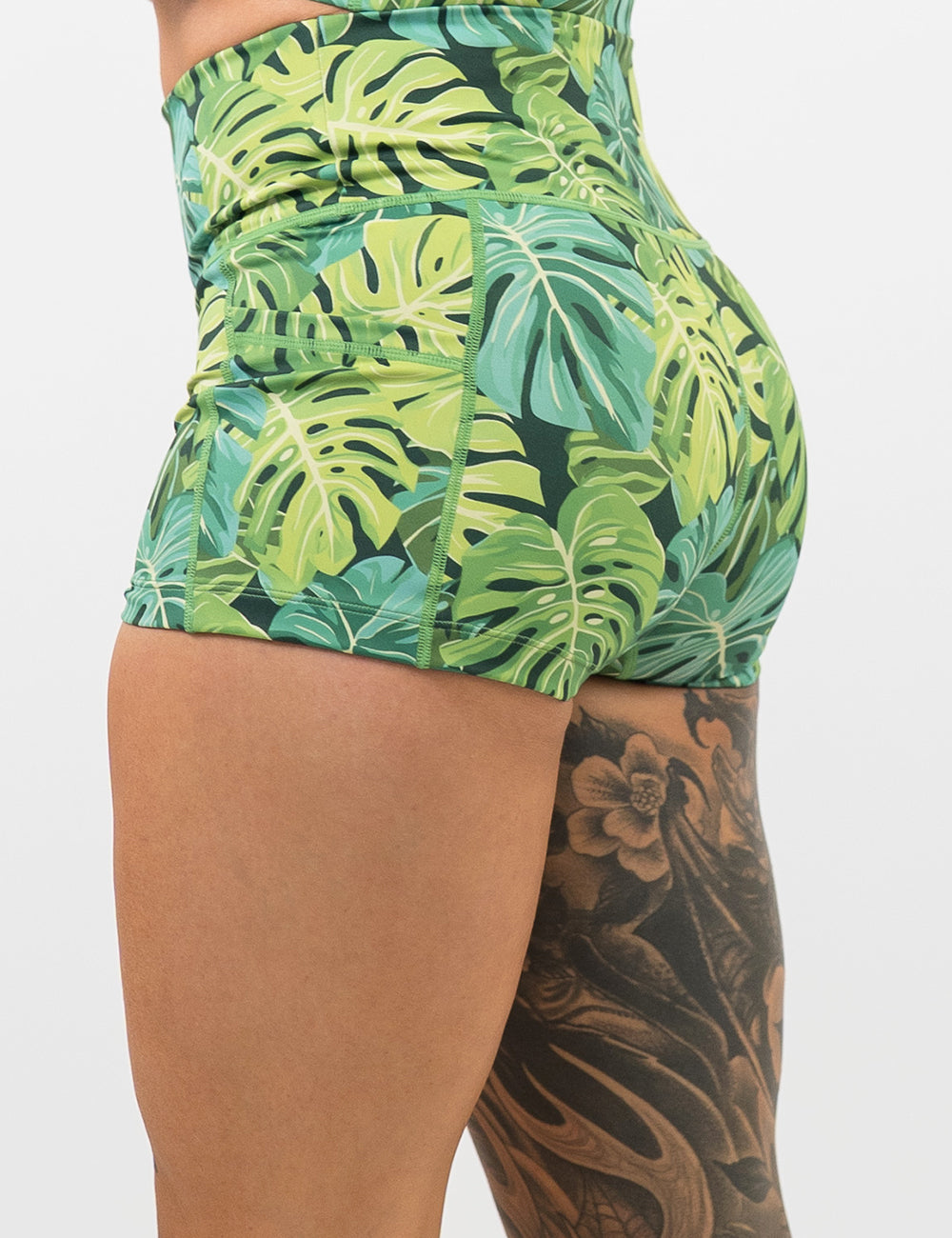 back of the 2.5 inch green tropical leaves shorts against a white background