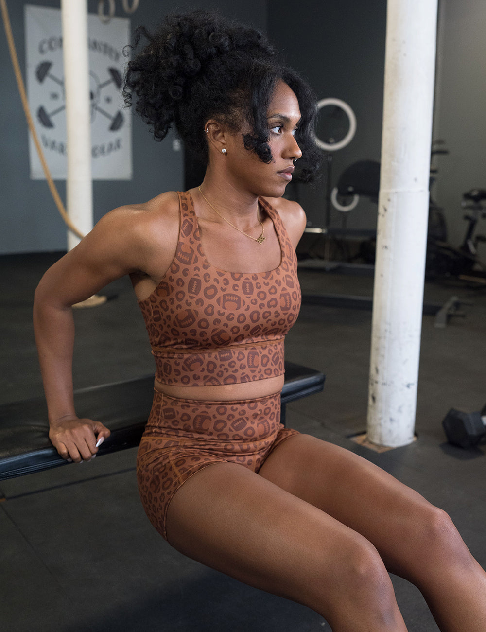 model wearing the football themed brown leopard print sports bra working out in the gym