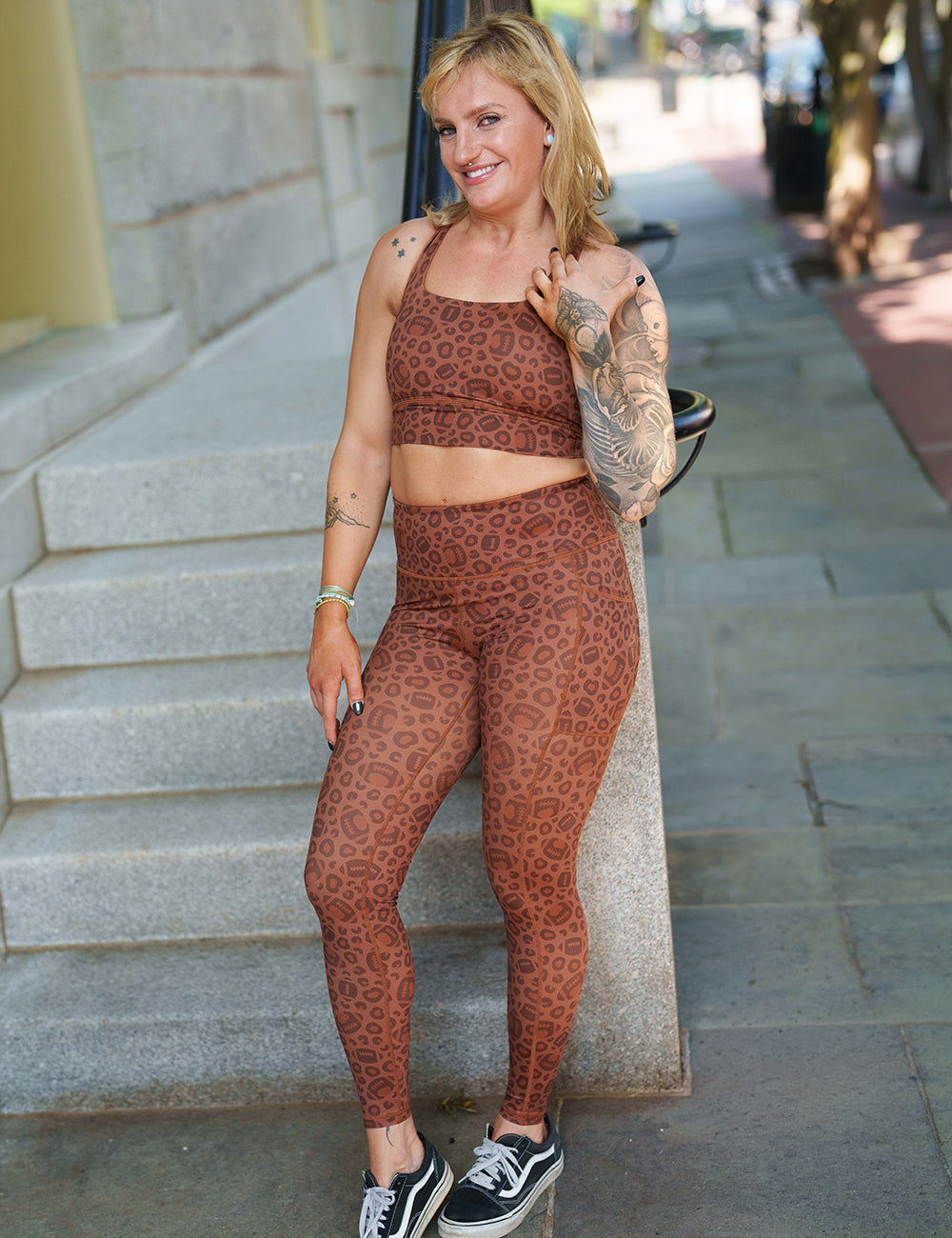 model wearing the football themed brown leopard print full length leggings and sports bra