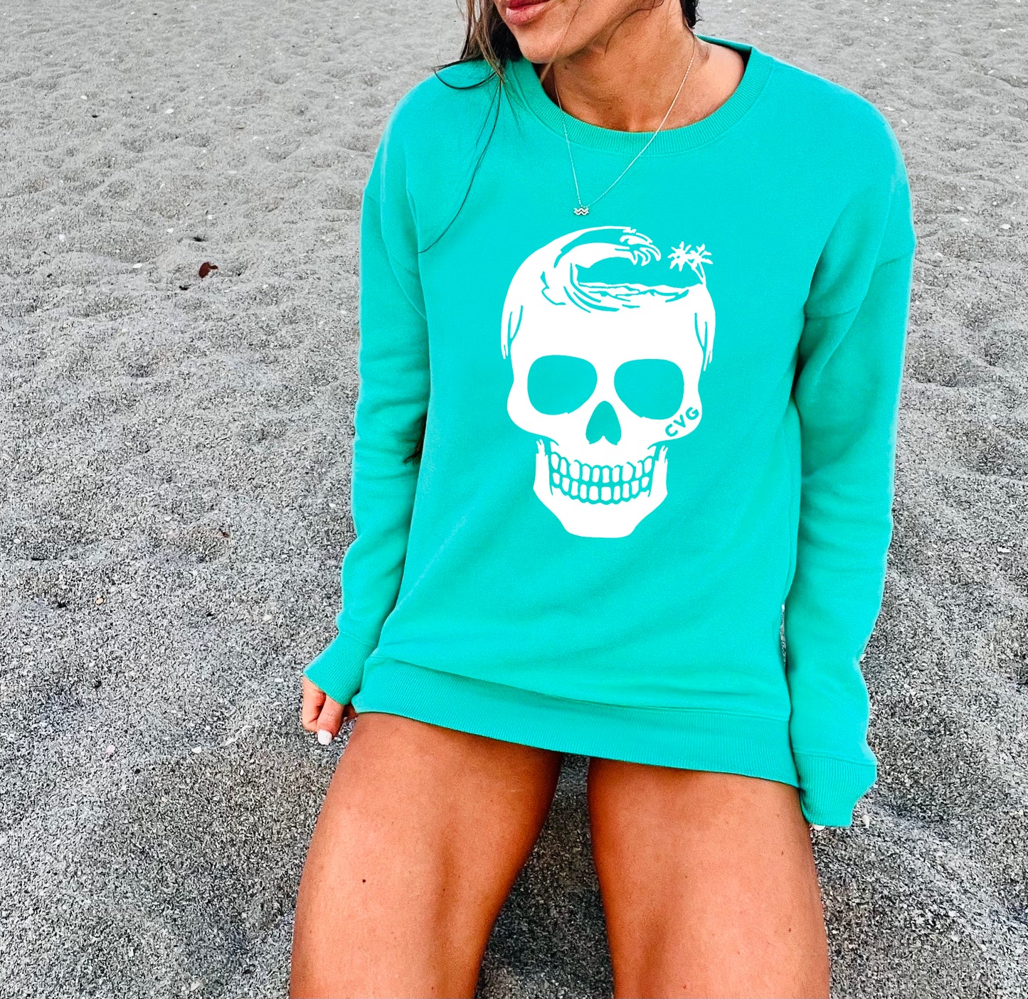 model wearing the mint crewneck with a white wave skull in the center