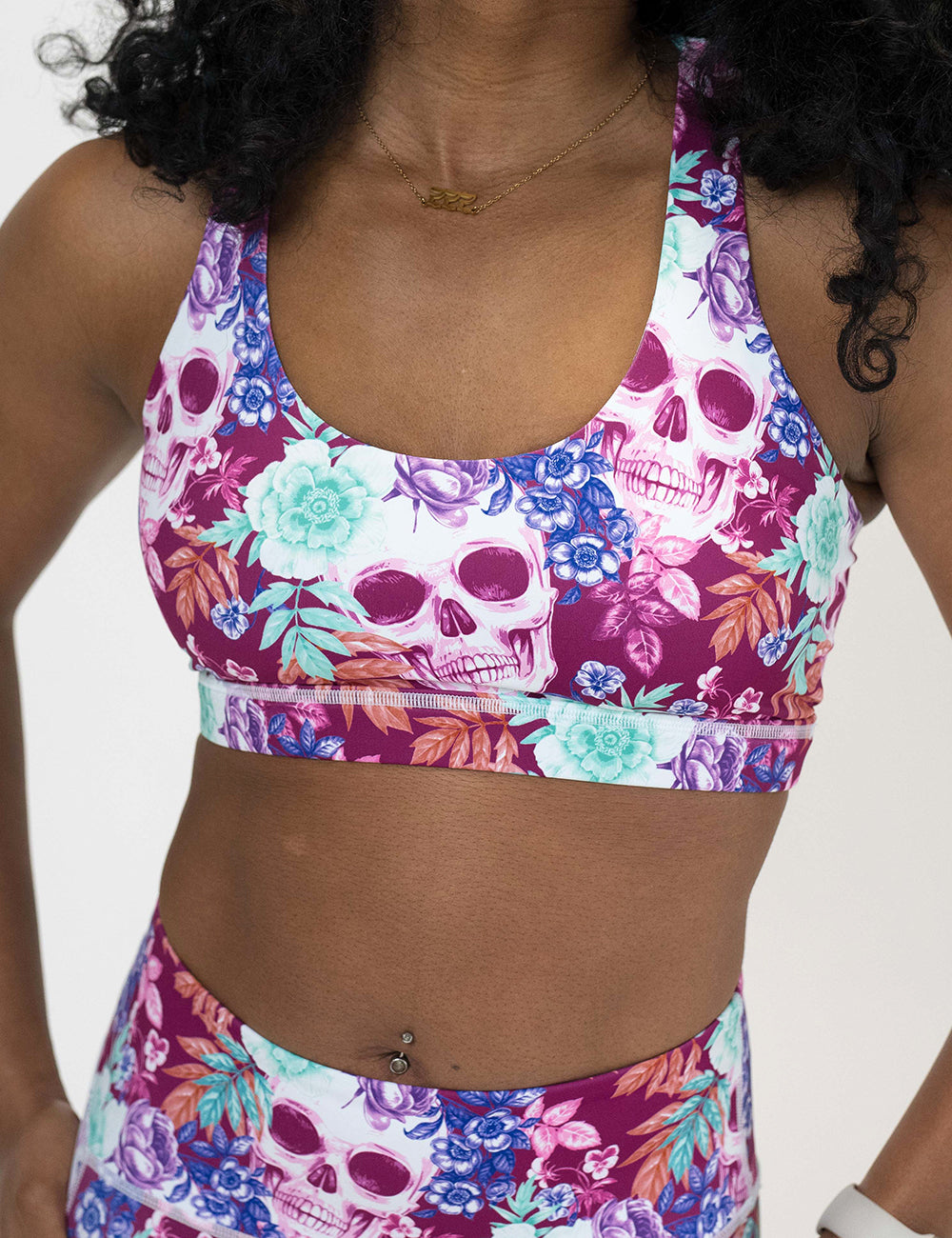 front of the skull and flower patterned sports bra against a white background