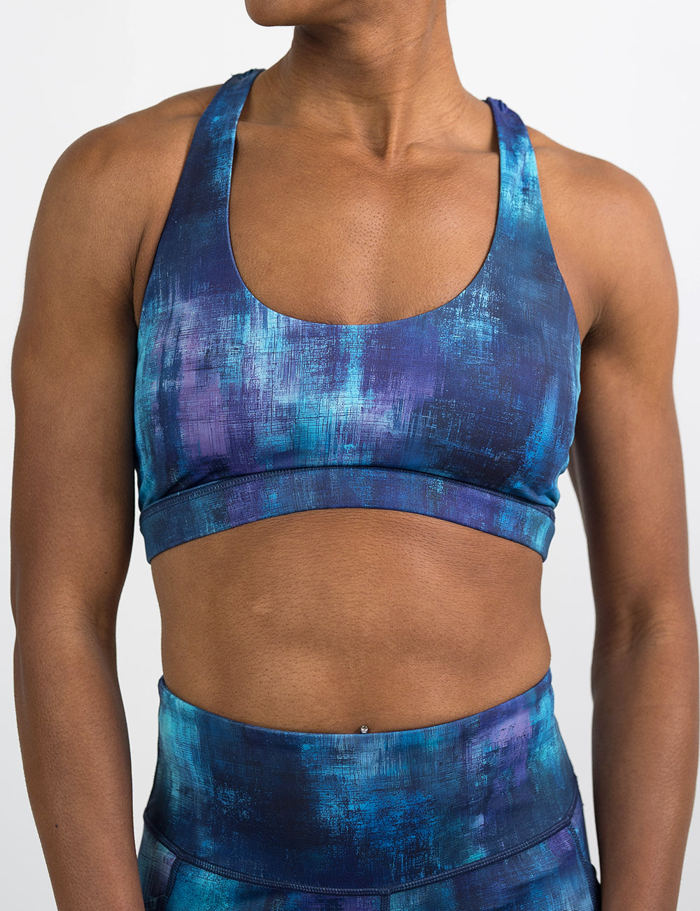 front of the blue, teal, and purple grunge concrete pattern bra against a white background