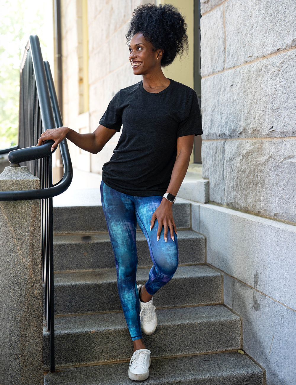 model wearing the blue, teal, and purple grunge concrete pattern full length leggings with a black tee