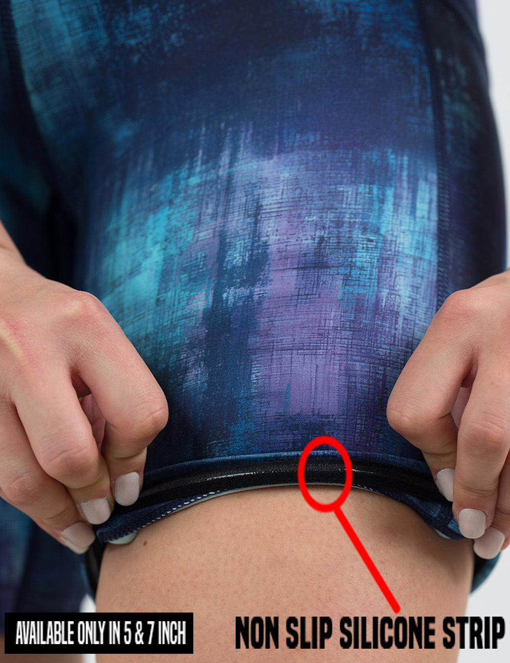close up of the blue, teal, and purple grunge concrete pattern shorts being rolled up to show the non slip silicone strip found in the 5 and 7 inch shorts