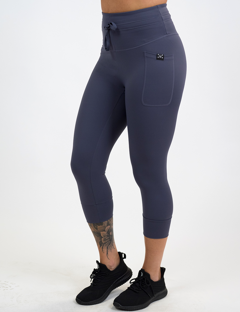 model wearing the capri purple twilight omni drawstring leggings facing the front against a white background
