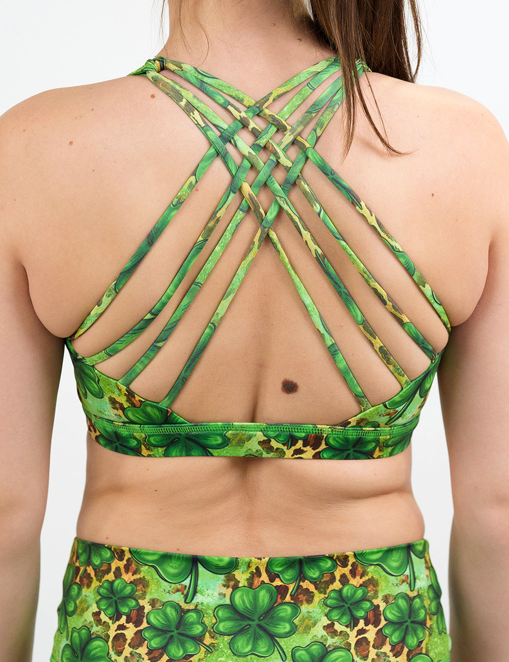 back of the clover pattern against a cheetah print and green background butterfly back bra against a white background