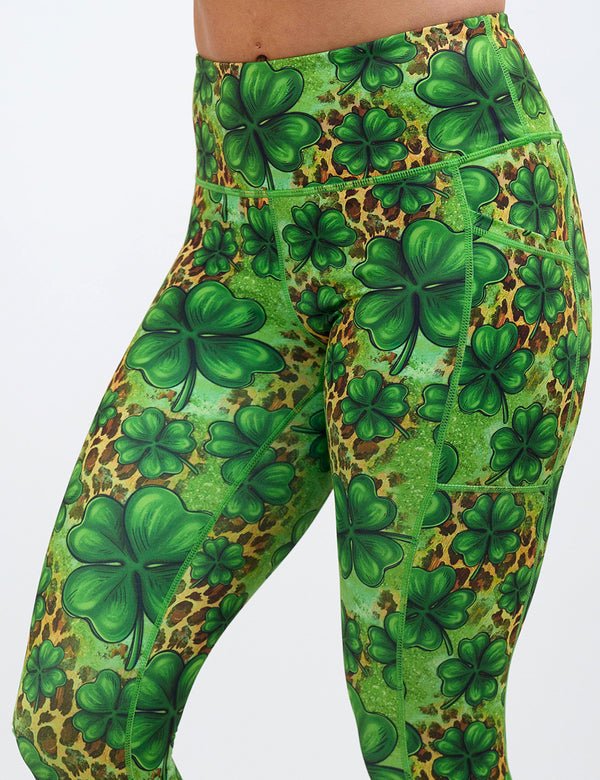 close up of the clover pattern against a cheetah print and green background leggings against a white background