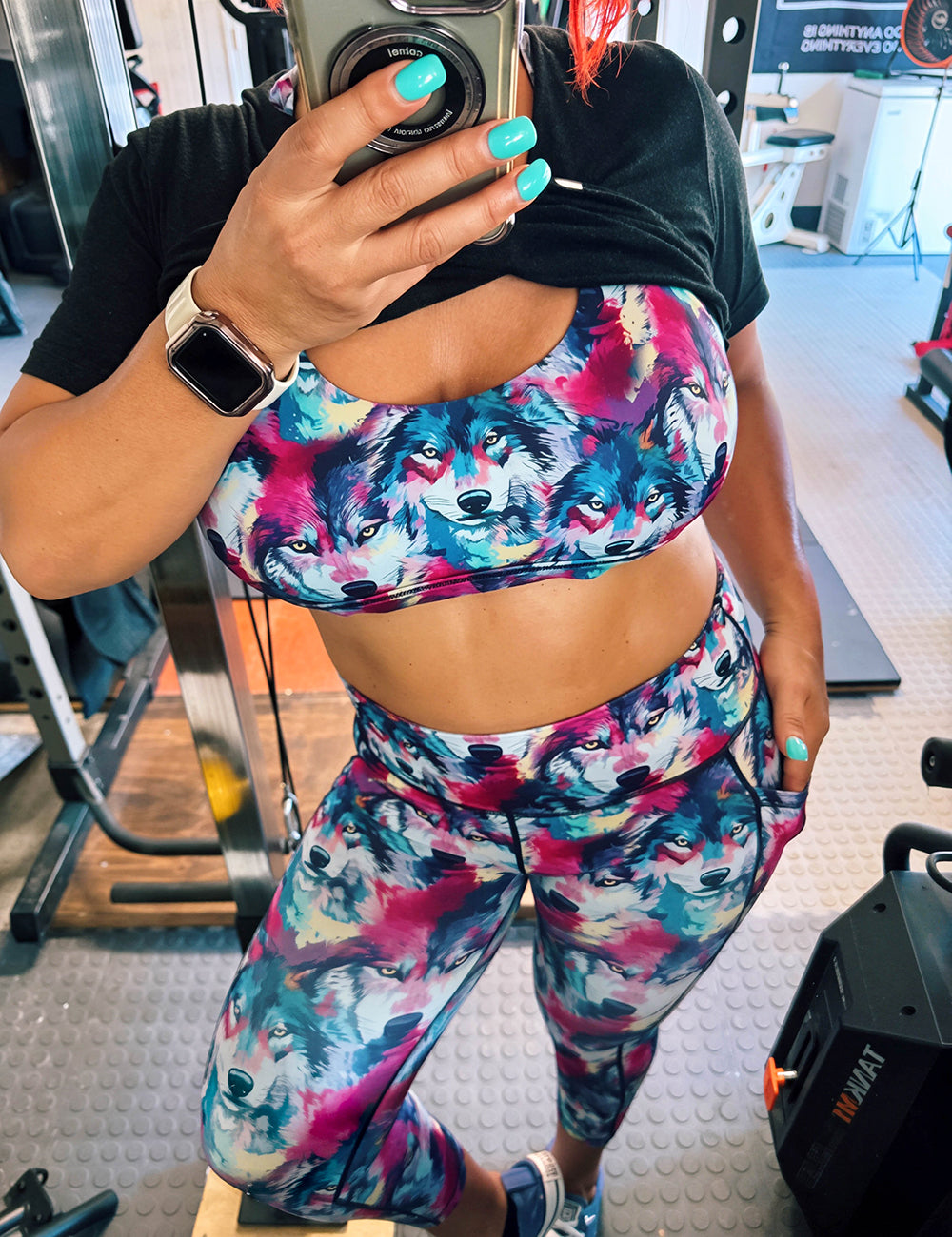 model wearing the watercolor wolves bra and leggings in the gym