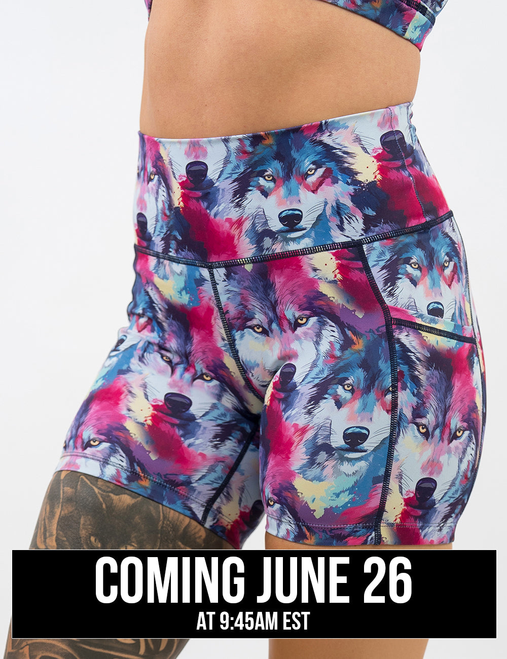front of the 5 inch blue, white, red, and yellow watercolor style wolves shorts against a white background, coming june 26th
