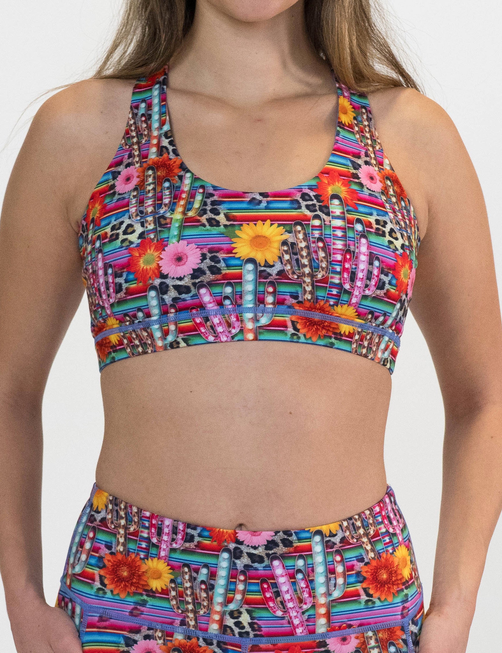 front of the colorful cactus and flower print sports bra