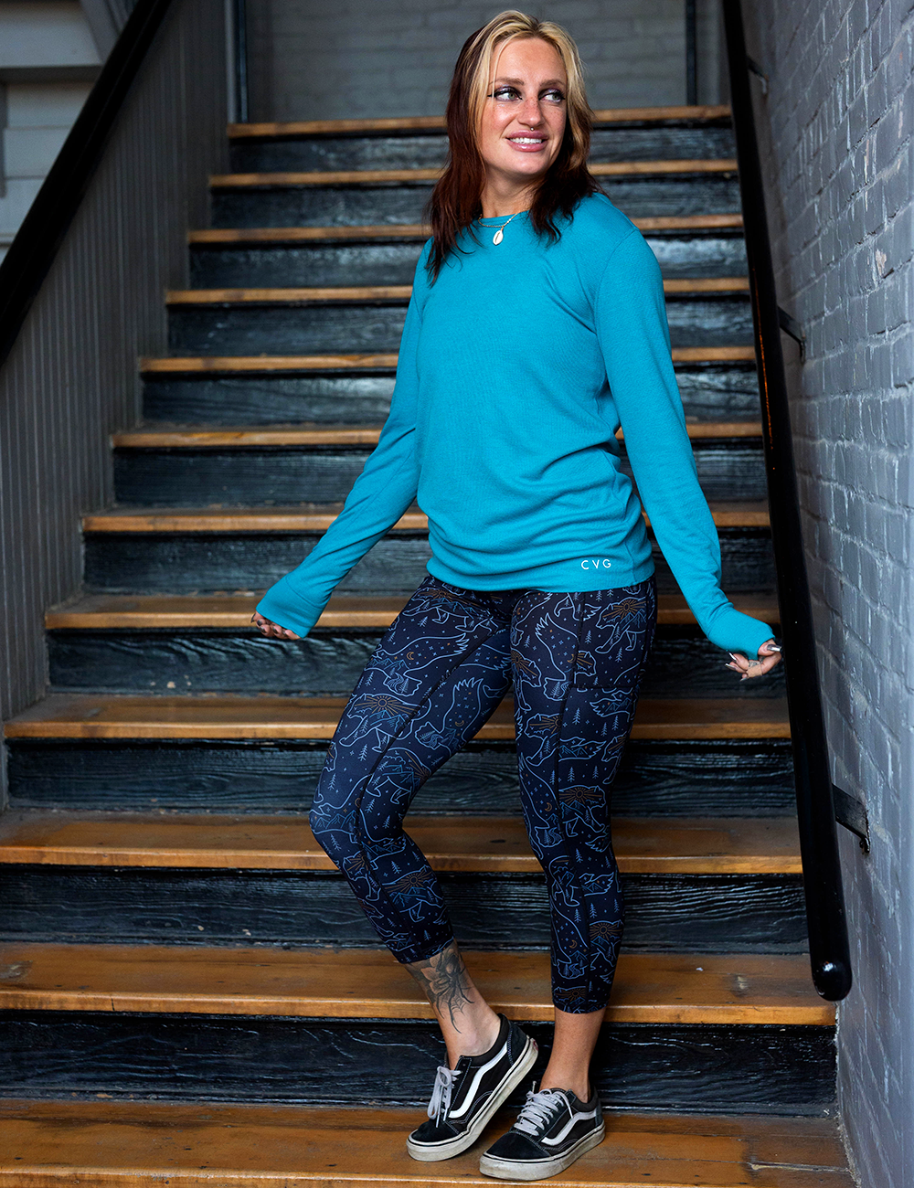 model wearing the bird and bear outlines against a dark background capri leggings posing in a stairwell