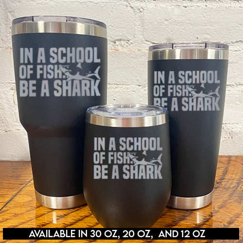 30oz, 12oz and 20oz black tumblers with silver saying "in a school of fish be a shark" with a shark cartoon over the word "fish"