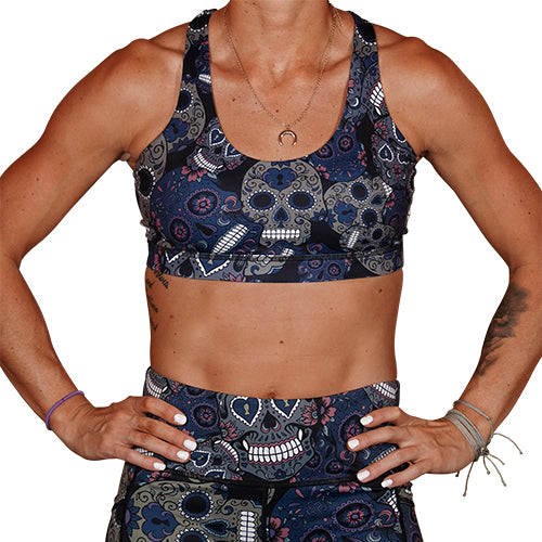 front view of blue, pink, grey and white sugar skull print sports bra