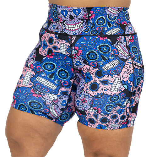 front view of blue, pink and teal sugar skull pattern on 7" shorts