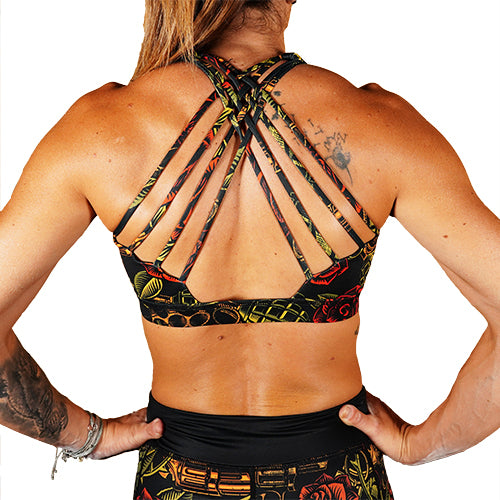 back view of butterfly back straps design on rose and gun patterned sports bra