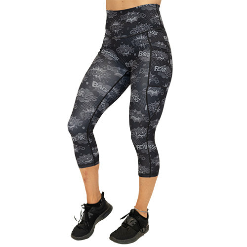 front view of capri length black leggings with comic book style action bubbles that say "badass", "fierce" and "dedication"
