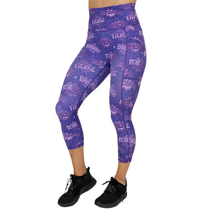 back view of capri length purple leggings with comic book style action bubbles that say "badass", "fierce" and "dedication"