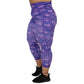 side view of capri length purple leggings with comic book style action bubbles that say "badass", "fierce" and "dedication"