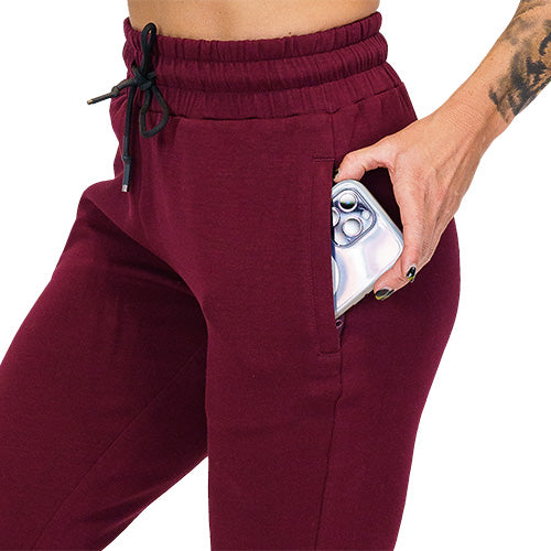 Close up photo of maroon joggers showing a phone fitting into the pocket