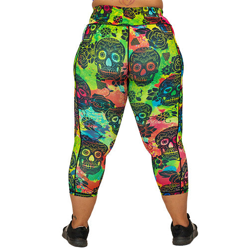 back view of capri length colorful tie dye leggings with black skull pattern