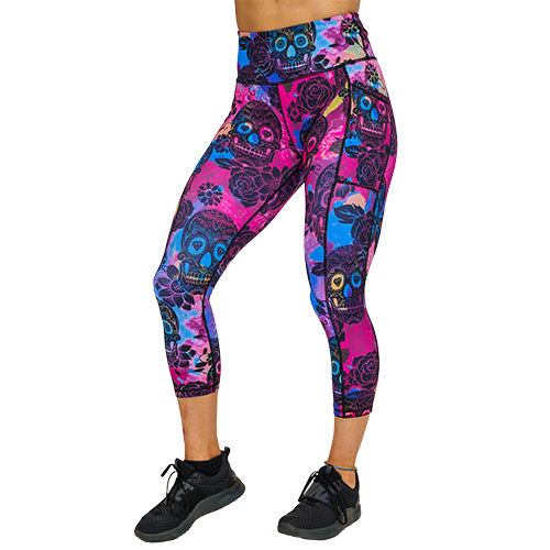 front view of capri length  purple, pink and blue tie dye leggings with black skull and rose pattern