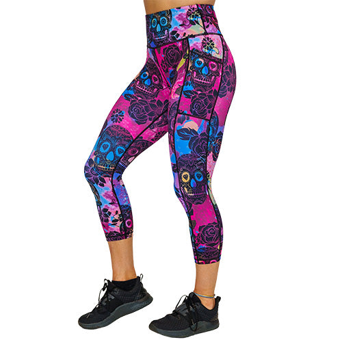 side view of capri length purple, pink and blue tie dye leggings with black skull and rose pattern