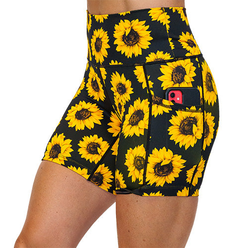 close up of side pocket that can hold a cell phone on the yellow flower shorts against a white background
