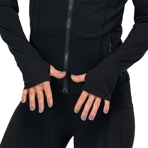 Photo of a model showing the sleeve thumbholes of the black zip up track jacket