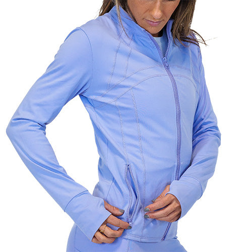 Photo of a model showing the zipper pockets on a periwinkle zip up track jacket.
