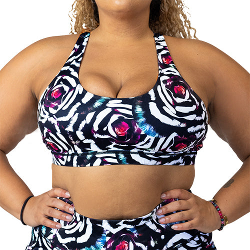 front view of white, black, pink and blue petals print sports bra