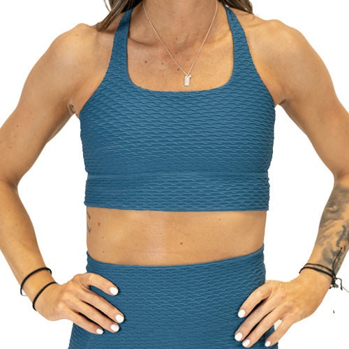 front view of solid teal textured print sports bra