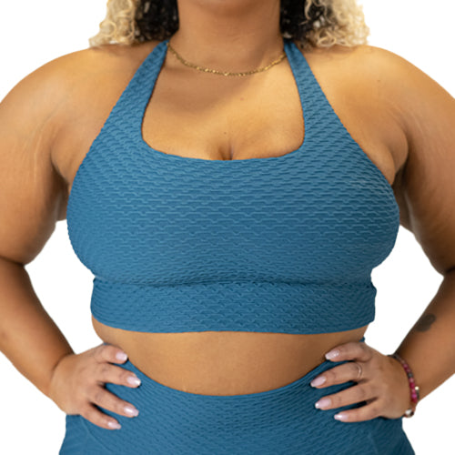 front view of solid teal textured print sports bra