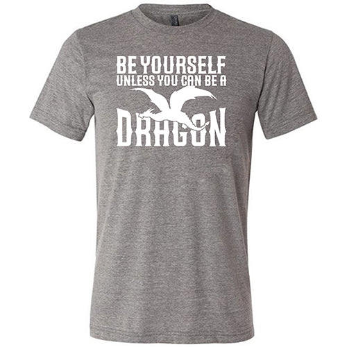 grey unisex shirt with the saying "Be Yourself Unless You Can Be A Dragon" on it in white