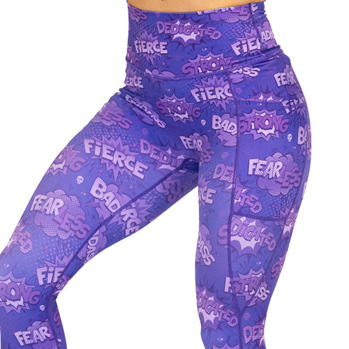 close up of purple leggings with comic book style action bubbles that say "badass", "fierce" and "dedication"