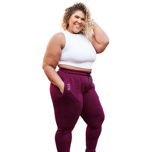 full body shot of a model wearing the maroon joggers and a white fitted crop top.