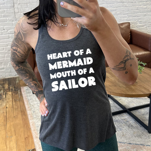 Model wearing a grey racerback tank with the saying "heart of a mermaid mouth of a sailor" in white