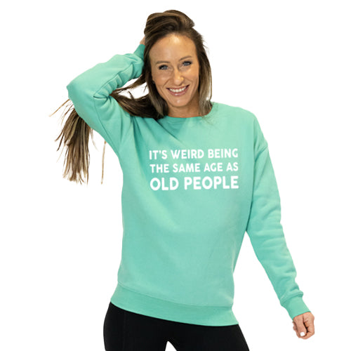 front view of spearmint crew neck with saying "it's weird being the same age as old people" in white