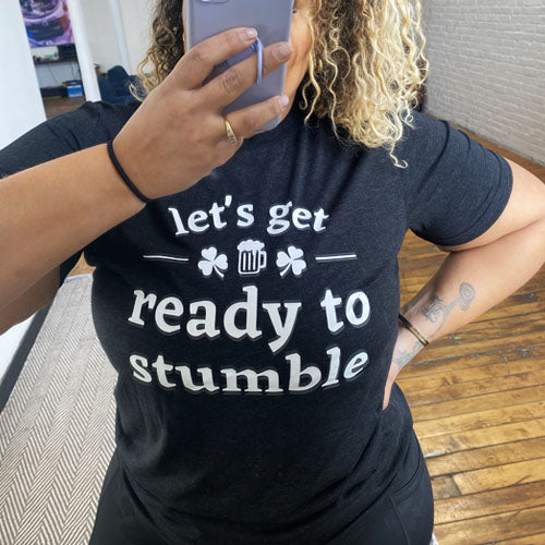 black unisex shirt with the saying "let's get ready to stumble" on it in white