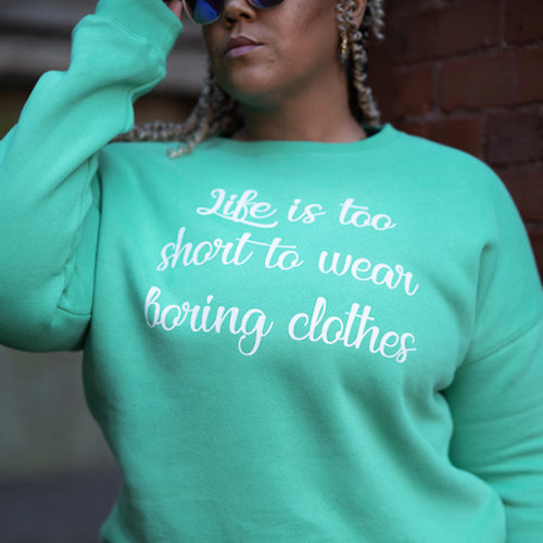 front view of spearmint crew neck with saying "life is too short to wear boring clothes" in white