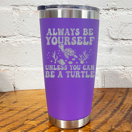 20oz purple tumbler with silver saying "always be yourself unless you can be a turtle" with turtle cartoon, seaweed, shells and bubbles