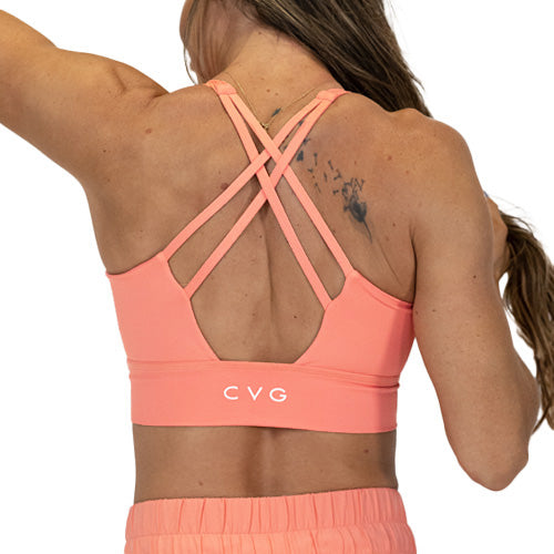 back view of butterfly back strap design on solid pink peach colored longline bra 